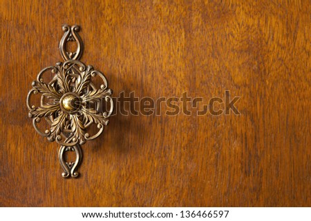 detail of wardrobe door or wooden brown background with decorative knob on left side