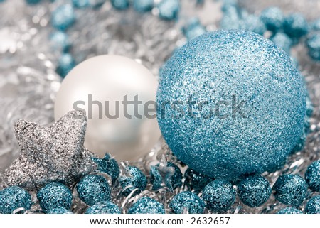 Blue and silver christmas balls on silver garlan with silver stars. Close-up.