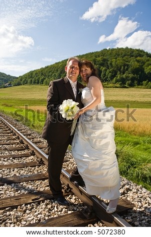 Bridal couple on rails, being in the nature. Great azure sky. Great summer!