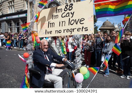 BRIGHTON, UK - AUG 13. An 88 years old gay man join the pride parade with his scooter and \'life with no regret\' sign at Brighton Pride Festival on August 13, 2011.