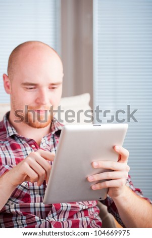 Focused man working and playing with tablet computer (lots of co