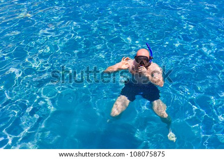 young man snorkeling with diving mask  in beautiful clear blue t