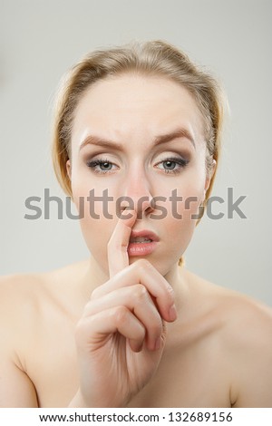 funny portrait of young bored woman picking nose, dorky silly funny face concept