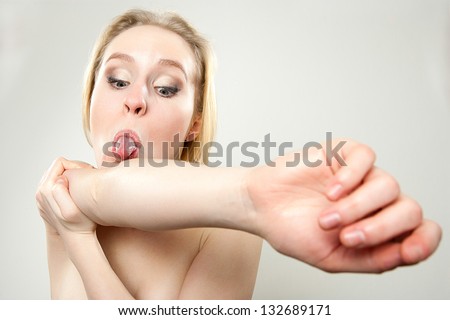 funny portrait of young woman trying to lick her elbow, dorky silly funny face concept