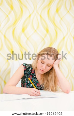 Beautiful young woman writing an exam and studying