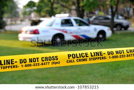 TORONTO-JULY 17: Police line Do not cross tape with police car in the background at the crime scene where  shooting leaves 2 dead and 21 injured on July 17, 2012 in Toronto