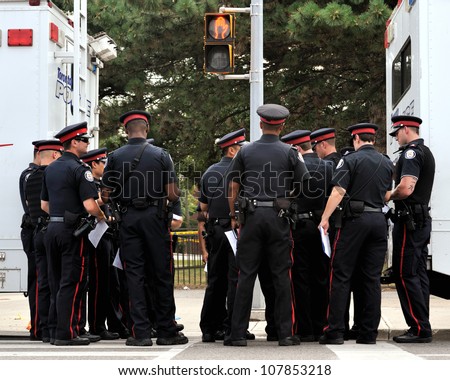 TORONTO-JULY 17: A group of police officers taking orders at the crime scene where shooting leaves 2 dead and 21 injured on July 17, 2012 in Toronto