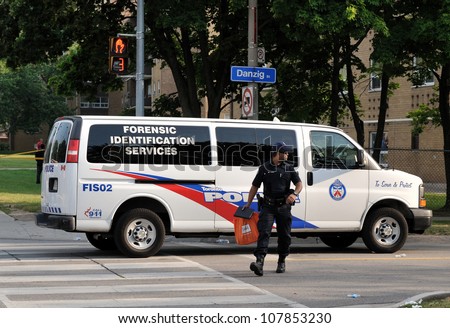 TORONTO-JULY 17: A Police officer from Toronto Forensic Identification Services Unit  at the crime scene where shooting leaves 2 dead and 21 injured on July 17, 2012 in Toronto