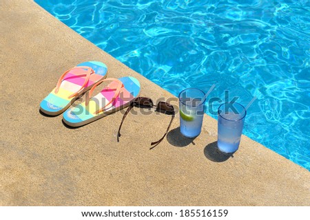 Two glasses of ice water, pear of sandals and womenÃ¢Â?Â?s sunglasses