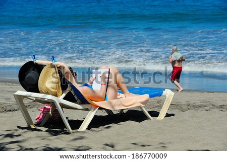 Woman writing in her diary at a beach