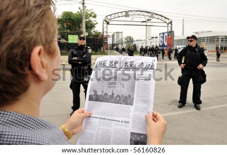 TORONTO-JUNE 27: Protester in front of the Toronto Film Studios reads the latest news update from protest organizers at G20 protest on June 27, 2010 in Toronto.