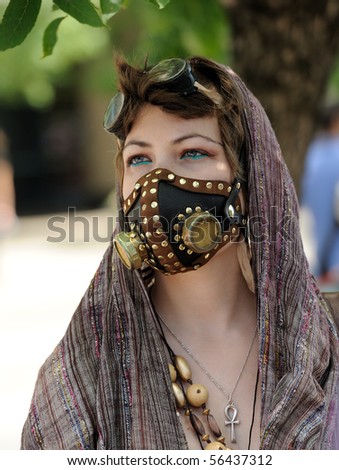 TORONTO - JULY 01:  Young woman, dressed in unique fashion, with decorative mask on face, watches the Canada Day parade in Toronto, July 01, 2010