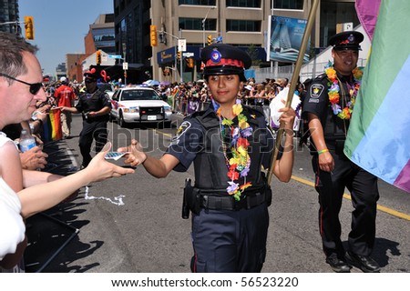 TORONTO - JULY 04: York policewoman  gives rainbow stickers at Pride parade in Toronto, July 04, 2010