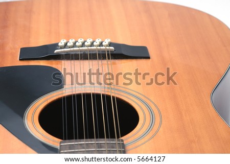 12 string guitar closeup of soundhole, bridge and lower body against a white background