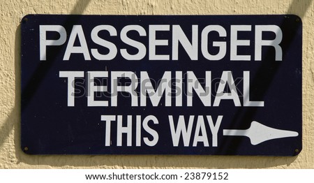 Black sign with white writing saying passenger terminal for a cruise ship port terminal.