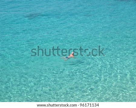 Seaside holidays Older man swimming in crystal clear water