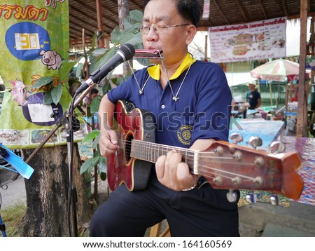 SAMUTPRAKRAN, THAILAND - FEBRUARY 11 :Unidentified street musician plays guitar at walking street market in Samutprakran,Thailand on February 11, 2012