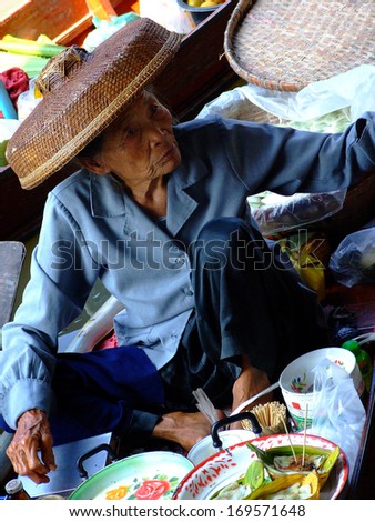 RATCHABURI,THAILAND -DECEMBER 8:Local merchant sell food and product at Damnoen Saduak floating market,on December 8,2007 in Ratchaburi,Thailand .Dumnoen Saduak is a very popular tourist attraction