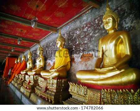 BANGKOK-JANUARY 4: Golden Buddha statues in a row inside the temple hall of Wat Suthat on January 4, 2012 in Bangkok, Thailand. Wat Suthat is a famous temple built during 17th century by King Narai.