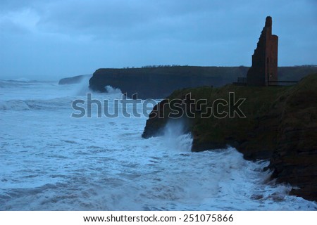Ballybunion castle and cliffs during a very bad storm with crashing waves