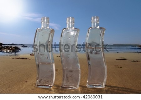 three bottles of pure natural water standing on the beach in kerry ireland