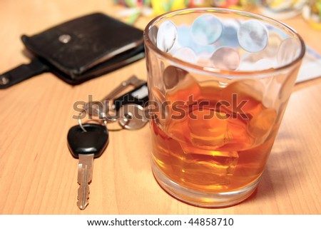 wallet whiskey glass and keys at office party on desk depicting do not drink and drive