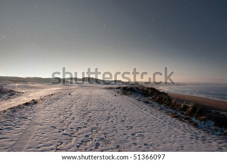 snow covering on a golf course in ireland in winter with starry night sky