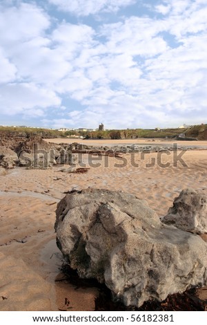 a rocky beach with castle on a warm day with a calm sea an ideal place to have a walk in ireland