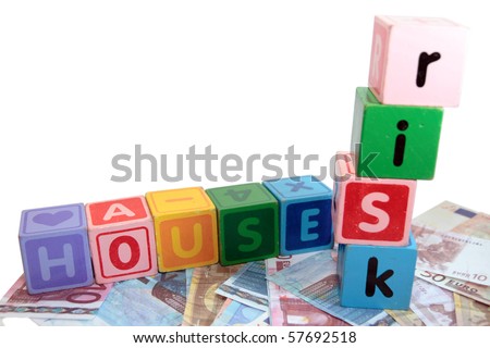 assorted childrens toy letter building blocks against a white background on money that spell house risk