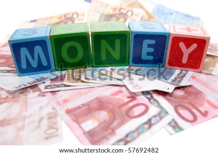 assorted childrens toy letter building blocks against a white background on money that spell money