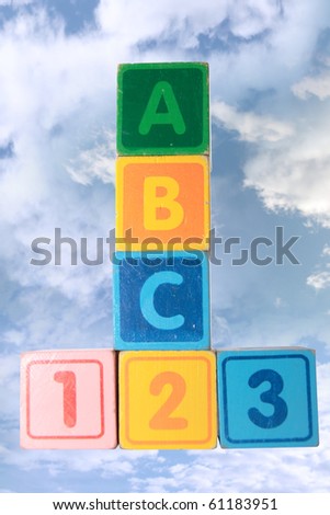 toy letter and number blocks against a cloudy background that spell abc 123 with clipping path