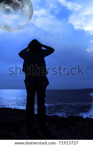 a lone woman looking sadly over the cliffs edge under the full moon in county clare ireland