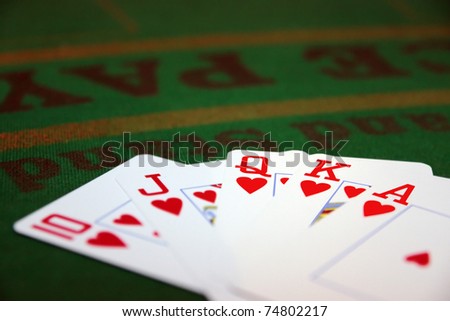green casino table with a hand of a royal flush in a poker game