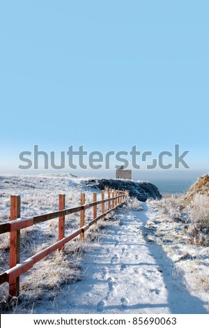 snow covered view of atlantic ocean and castle in ballybunion on a frosty snow covered winters day
