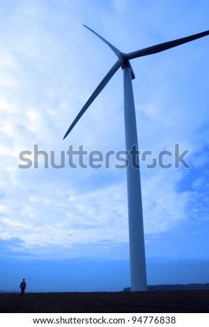 woman beside a windmill on lush irish countryside landscape in glenough county tipperary ireland
