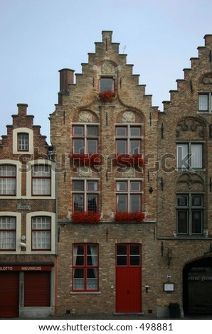 a building in Brugges Belgium with flowers in the windows.