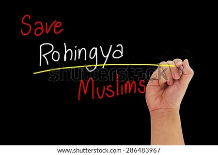 hand with pen writing Save Rohingya Muslims from human trafficking isolated on black background