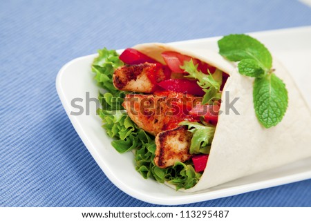 Healthy chicken tortilla wrap with lettuce, tomatoes, capsicum and  peri peri sauce