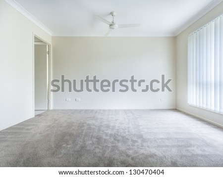 Large Empty Bedroom With Ceiling Fan And Curtains