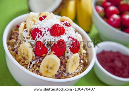 Acai berry bowl with granola, bananas, strawberries and shredded coconut