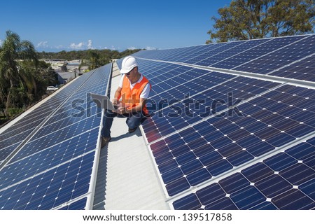 Solar panel technician on roof