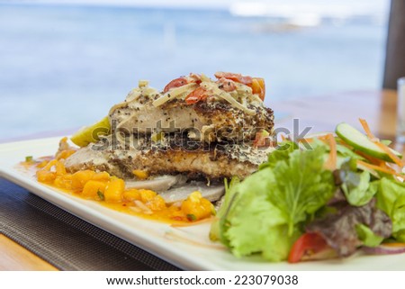 Grilled coconut fish with mango sauce and salad