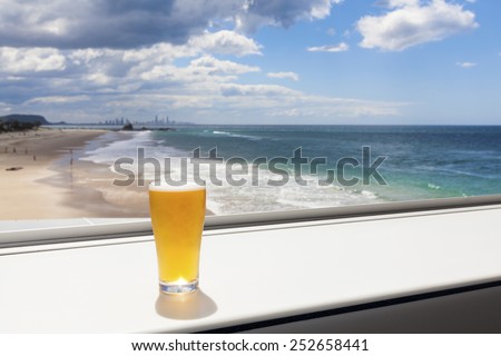 Cold beer on tropical beach with blue water