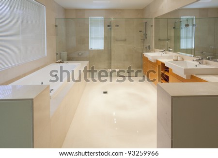 Modern marble bathroom with twin sinks, shower and bath tub