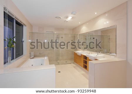 Modern marble bathroom with twin sinks, shower and bath tub
