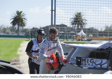 MELBOURNE, AUSTRALIA - MARCH 17 Michael Shumacher caring for his car after he runs wide and gets stuck in the gravel trap at turn 9 on March 17, 2012 in Melbourne, Australia