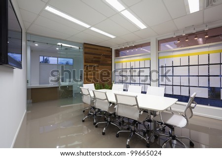 New board room with table, chairs and LCD display on wall.