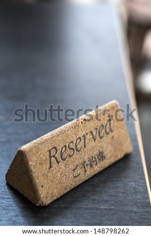 cork made reserved sign on black table