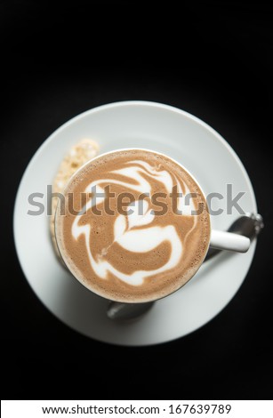 Hot coffee with latte art  with latte art on black table