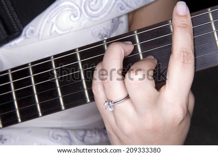 Diamond ring on hand playing guitar.close up
